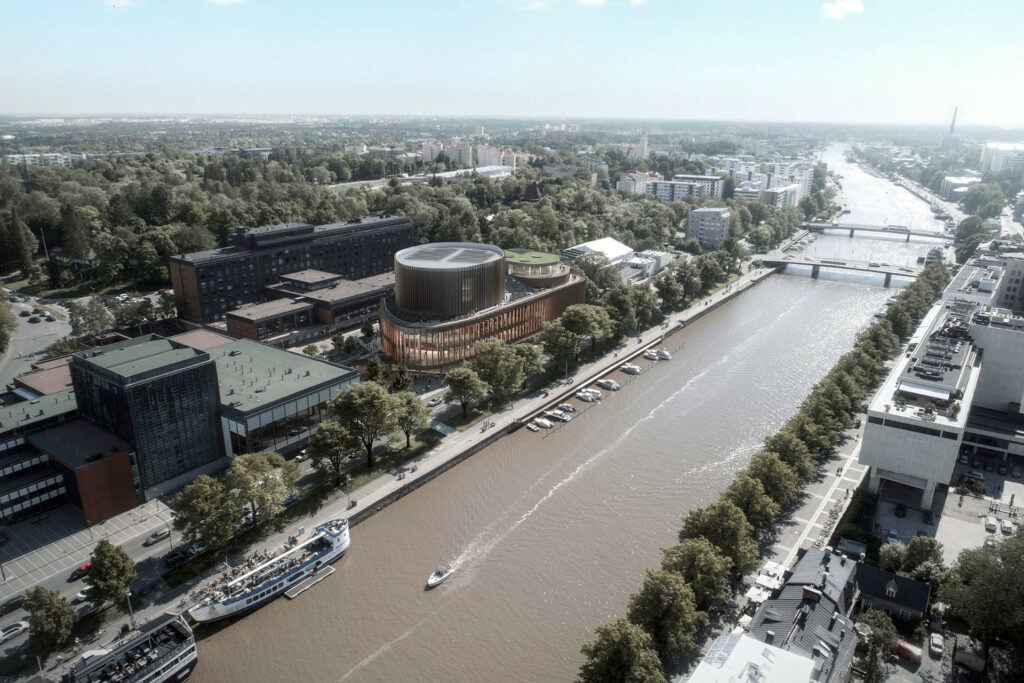 Kuva Aurajoesta kesäisenä päivänä, keskellä joki, molemmilla puolilla kaupunkimaisema