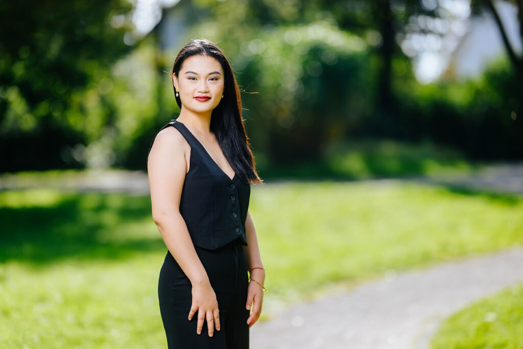 Nainen mustassa mekossa kesäisessä maisemassa